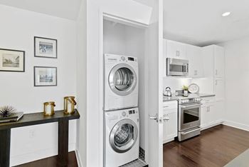A modern kitchen with a washer and dryer built into the cabinetry.